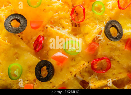 Primo piano dettaglio di nacho tortilla chips con olive e peperoncino Foto Stock