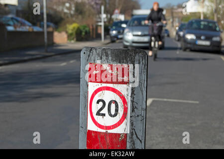 British 20mph segnale di limite di velocità che si è avvicinato da un ciclista e una macchina a Twickenham, middlesex, Inghilterra Foto Stock