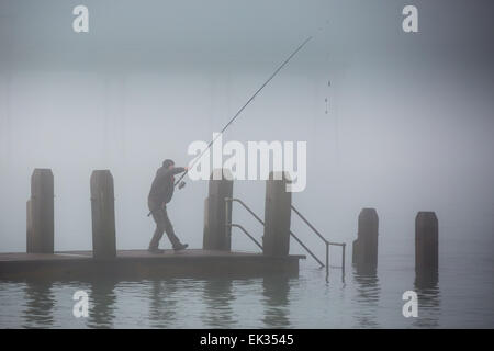 Aberystwyth, Wales, Regno Unito. Il 6 aprile 2015. Il Lunedì di Pasqua. Meteo. Un pescatore di preparazione al cast di un pontile in legno in una fitta nebbia di mare. Aberystwyth pier debolmente visibile dietro. Credito: Alan Hale/Alamy Live News Foto Stock