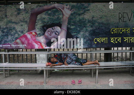 Una donna senzatetto prendendo un pisolino sul Bus stop all università di Dhaka area a Dhaka, nel Bangladesh. Foto Stock