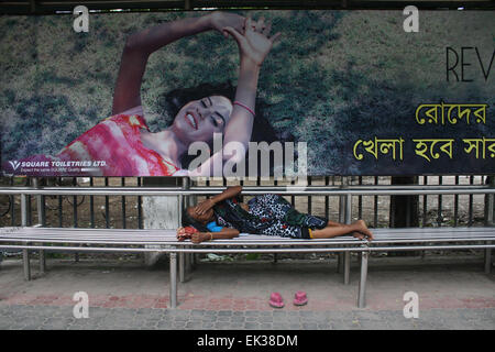 Una donna senzatetto prendendo un pisolino sul Bus stop all università di Dhaka area a Dhaka, nel Bangladesh. Foto Stock