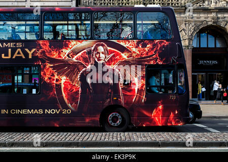 Un autobus Lothian bus su Princes Street, Edimburgo con un annuncio pubblicitario per la fame di giochi: Mockingjay parte 1. Foto Stock