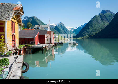 Vista sul fiordo Fjaerlandsfjord e il piccolo villaggio di Mundal (o Fjaerland) con alcune montagne innevate in Norvegia. Foto Stock