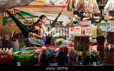 Un venditore e sua figlia godendo il tempo insieme a Kampot mercato, Cambogia. Foto Stock
