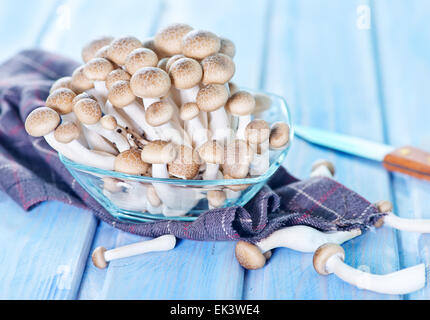 Materie di funghi in ciotola di vetro e su un tavolo Foto Stock