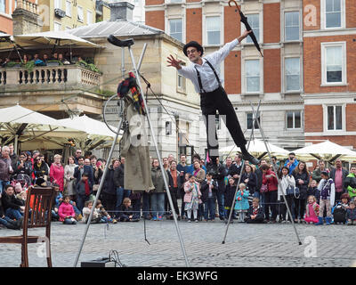 Un funambolo intrattenere una folla in Covent Garden London REGNO UNITO Foto Stock