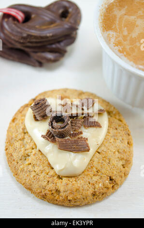 Farina di avena biscotti ricoperti di cioccolato e crema su sfondo bianco Foto Stock