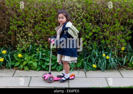 Un bambino che gioca sul suo scooter, Sussex, Regno Unito Foto Stock
