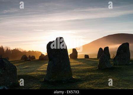 Sunrise colpisce le pietre permanente al Castlerigg Stone Circle Lake District Cumbria Regno Unito Foto Stock