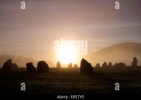 Sunrise diffusa dalla mattina presto la nebbia a Castlerigg Stone Circle Lake District Cumbria Regno Unito Foto Stock