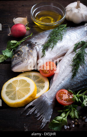 Materie dorada pesce con ingredienti su sfondo di legno,fuoco selettivo Foto Stock