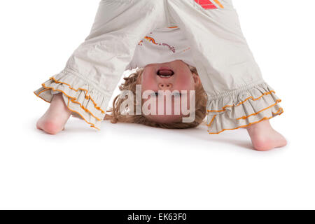 Bimba di tre anni in piedi su mani e piedi su sfondo bianco Foto Stock