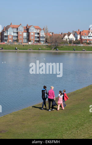 Famiglia camminando lungo la riva del lago Fairhaven a Lytham sulla costa di Lancashire Foto Stock