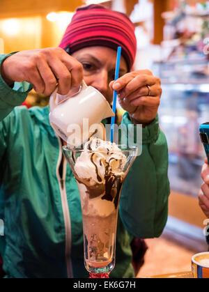 Donna versando caffè espresso sul gelato fantasia trattare Foto Stock