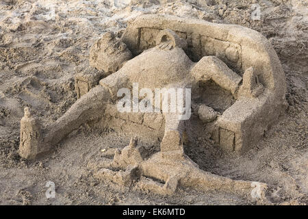 IQUIQUE, Cile - 10 febbraio 2015: la scultura di sabbia sulla spiaggia di Cavancha mostra una persona sdraiata su un banco di lavoro con una bottiglia Foto Stock