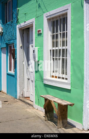 IQUIQUE, Cile - 4 febbraio 2015: il verde e il blu dipinto di case di legno con un banco di fronte su Pedro Lagos street Foto Stock