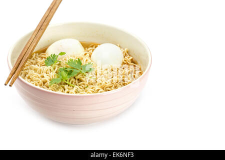 Tagliatelle con uova sode nella ciotola e bacchette isolati su sfondo bianco Foto Stock