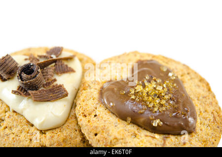 Farina di avena biscotti ricoperti di cioccolato e crema su sfondo bianco Foto Stock