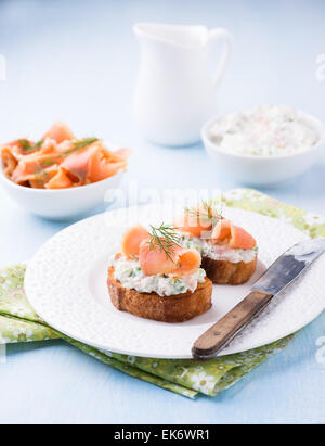 Crostino con salmone affumicato e crema di formaggio sulla piastra, il fuoco selettivo Foto Stock