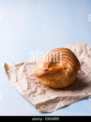 Bignè eclair anello con crema pasticcera su sfondo blu, il fuoco selettivo Foto Stock