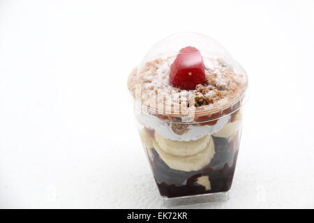Banoffee pie in un bicchiere rovesciato con caremel e panna montata Foto Stock