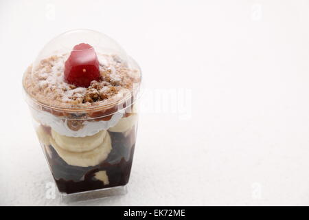 Banoffee pie in un bicchiere rovesciato con caremel e panna montata Foto Stock
