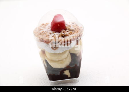 Banoffee pie in un bicchiere rovesciato con caremel e panna montata Foto Stock