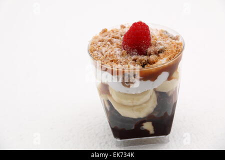 Banoffee pie in un bicchiere rovesciato con caremel e panna montata Foto Stock