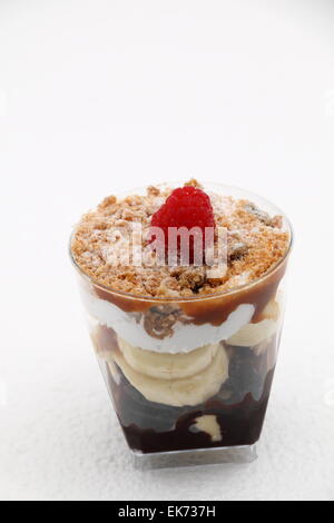 Banoffee pie in un bicchiere rovesciato con caremel e panna montata Foto Stock