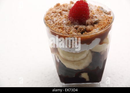 Banoffee pie in un bicchiere rovesciato con caremel e panna montata Foto Stock