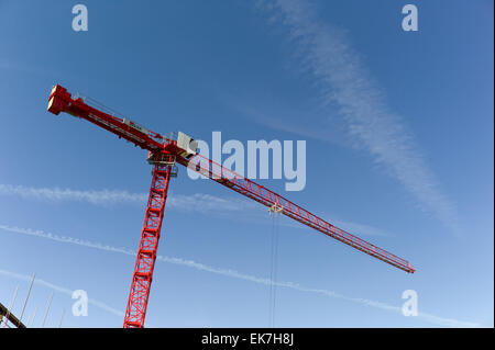 Alto edificio rosso gru contro il cielo blu Foto Stock