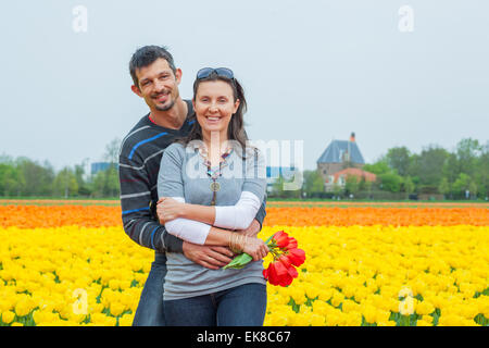 Nel campo di tulipani. Felice coppia giovane nel campo di tulipani Foto Stock