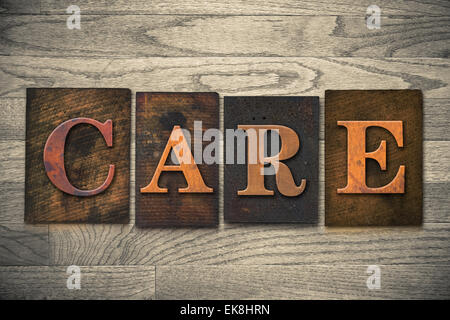 La parola 'cura' tema scritto in vintage, inchiostro colorato, in legno tipo di stampa in rilievo su una grana di legno dello sfondo. Foto Stock