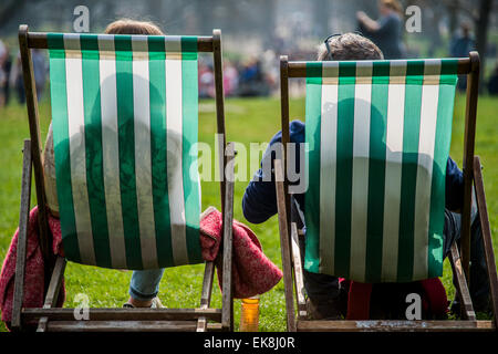 Londra, Regno Unito. 08 apr, 2015. Il sole di primavera fa risaltare i lavoratori e i turisti a pranzo. Essi godetevi il relax nelle sedie a sdraio o anche il loro utilizzo come uffici esterni. Green Park, Londra, 08 Apr 2015. Credito: Guy Bell/Alamy Live News Foto Stock