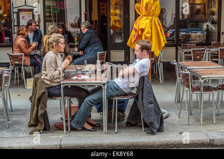 Una giovane coppia cenare e rilassarsi sorseggiando una tazza di caffè in uno di Londra molti al di fuori di caffè Londra Inghilterra REGNO UNITO Foto Stock
