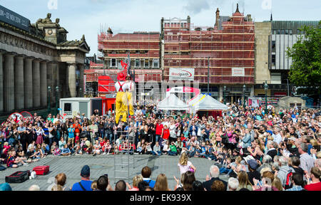 Artisti di strada giocoleria su scale vestita come vigili del fuoco, Edinburgh Festival Fringe Foto Stock