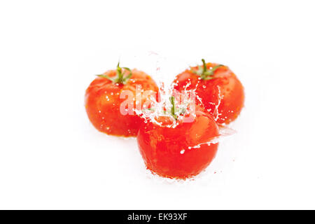 Pomodori con gocce di acqua isolato su bianco Foto Stock