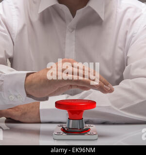 Mano premendo il pulsante di emergenza, una camicia bianca e riflessione. simbolo di urgenza e di problem solving Foto Stock