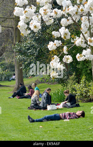 Londra, Inghilterra, Regno Unito. Persone per godersi il sole in città durante le ore del pranzo in Victoria Embankment Gardens Foto Stock