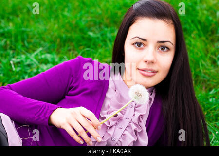 Ritratto di una giovane e bella donna con tarassaco Foto Stock