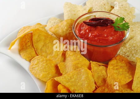 Pomodoro-chili dip con il salato e formaggio tacos su bianco (messa a fuoco selettiva, messa a fuoco sulla parte anteriore del tacos e il dip) Foto Stock