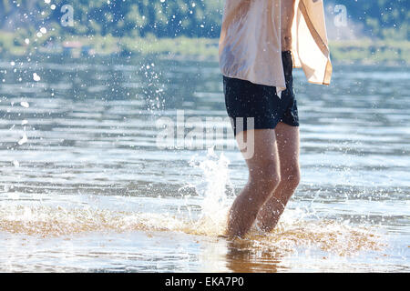 Le gambe di un uomo che si tuffa in acqua Foto Stock