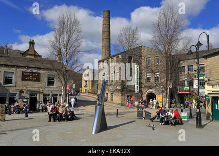 I turisti relax dall'ago Fustian scultura in St George Square, Hebden Bridge, West Yorkshire, Inghilterra, Regno Unito. Foto Stock