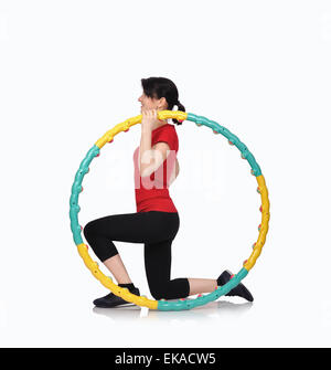 Donna seduta con colore hula hoop su sfondo bianco Foto Stock