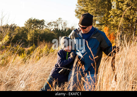 Padre e figlio escursionismo nel campo Foto Stock