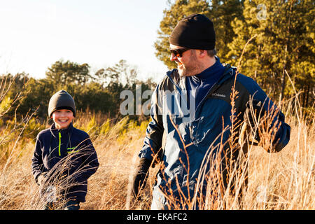 Padre e figlio escursionismo nel campo Foto Stock