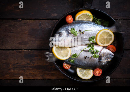 Glithead fishe in padella con ingredienti su sfondo di legno con uno spazio vuoto Foto Stock