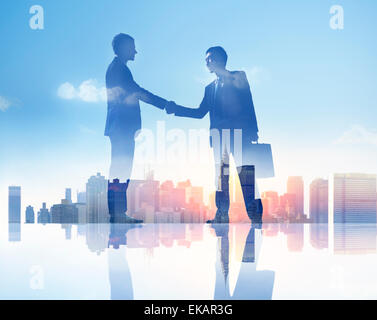 Sagome di due imprenditori avente una stretta di mano Foto Stock