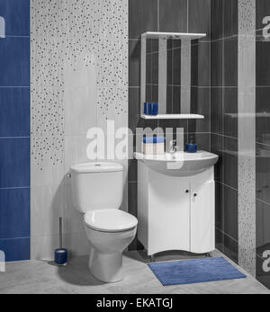 Un lusso interno del moderno bagno con lavandino e wc; decorate con blu e piastrelle grigie Foto Stock