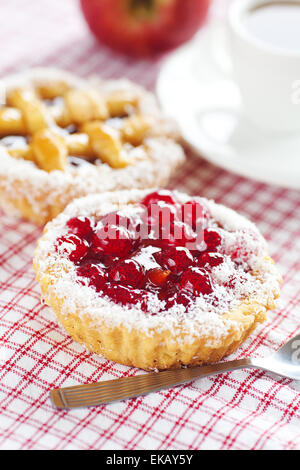 Bella torta con frutti di bosco e tè su plaid tessuto Foto Stock